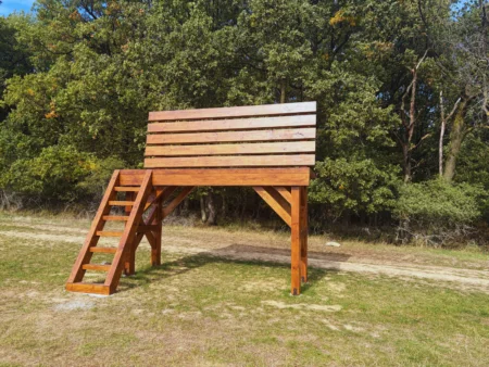 Obrovská drevená lavička pri lese s výhľadom na okolité polia a kopce v okolí Brezolúp.