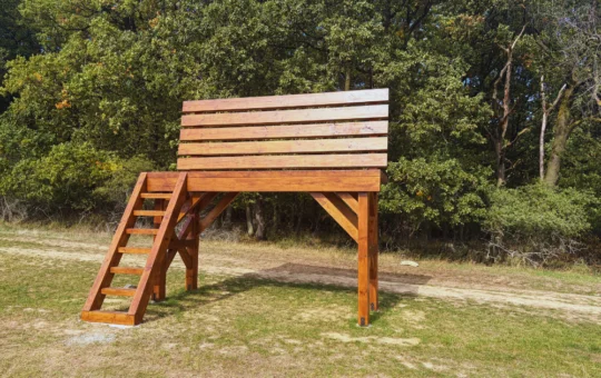 Obrovská drevená lavička pri lese s výhľadom na okolité polia a kopce v okolí Brezolúp.